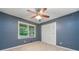 Bedroom featuring a blue wall, and a ceiling fan with light kit, with window and closet at 2578 Morgan Lake Ne Dr, Marietta, GA 30066