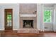 Cozy fireplace with brick surround, white mantel, and view of front door and window at 2578 Morgan Lake Ne Dr, Marietta, GA 30066