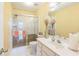 Bright bathroom featuring a shower, vanity with modern faucet, and white tile flooring at 266 Monarch Village Way, Stockbridge, GA 30281