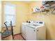 Well-lit laundry room with washer and dryer, plus storage shelves at 266 Monarch Village Way, Stockbridge, GA 30281