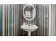 Cozy powder room featuring a pedestal sink with an oval mirror and stripped wallpaper at 3614 Clearbrooke Way, Duluth, GA 30097