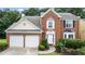 Close-up of a brick two-story home with a two-car garage, front yard landscaping, and arched window feature at 3614 Clearbrooke Way, Duluth, GA 30097