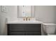 Bathroom features a vanity with marble countertop, gray cabinets, gold hardware and fixtures, plus a toilet at 202 Dawson Dr, Woodstock, GA 30188