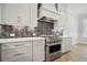 Modern kitchen featuring stainless steel oven, herringbone backsplash, and white cabinets at 202 Dawson Dr, Woodstock, GA 30188