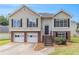 Two-story home with a two-car garage, neutral siding and a welcoming front porch with manicured yard at 2175 Golden Valley Dr, Lawrenceville, GA 30043