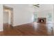Spacious living room with hardwood floors, a brick fireplace, and abundant natural light from the windows and glass door at 2175 Golden Valley Dr, Lawrenceville, GA 30043