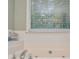 Close-up on the bathroom soaking tub with jets, a large window and tile wall surround at 3488 Pebble Brook Ln, Stockbridge, GA 30281