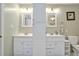 Bathroom featuring separate vanities with white cabinets, mirrors, and a storage tower at 3488 Pebble Brook Ln, Stockbridge, GA 30281