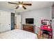Bedroom featuring a pink makeup vanity, bed, ceiling fan, and dark dresser at 3488 Pebble Brook Ln, Stockbridge, GA 30281