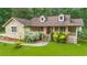 Charming home featuring a stone facade, dormer windows, a well-manicured lawn and abundant landscaping at 3488 Pebble Brook Ln, Stockbridge, GA 30281