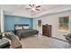 Spacious main bedroom featuring tray ceilings, a ceiling fan, and natural light from two windows at 3488 Pebble Brook Ln, Stockbridge, GA 30281