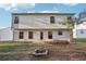 Back of house with a small patio area, fire pit, and a view of trees at 382 Daffodil Dr, Temple, GA 30179