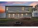 Two-story home's rear exterior features vinyl siding, windows, a door, and a brick firepit in the backyard at 382 Daffodil Dr, Temple, GA 30179