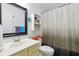 Bright bathroom featuring a vanity with modern fixtures, a mirror, shelving, and a shower with a curtain at 570 White Stag Ct, Suwanee, GA 30024