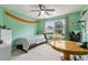 Cozy bedroom featuring green walls, a comfortable bed, and a spacious desk area at 570 White Stag Ct, Suwanee, GA 30024