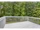 White deck with wooden floors overlooking lush greenery, perfect for outdoor relaxation and entertainment at 570 White Stag Ct, Suwanee, GA 30024