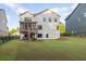 Spacious backyard with green grass surrounding a two-story home with a screened deck at 401 Pirkle Ave, Buford, GA 30518