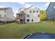 Expansive backyard featuring lush lawn, trampoline, and a modern home with a screened porch at 401 Pirkle Ave, Buford, GA 30518