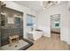Bright bathroom featuring a rainfall shower behind glass, soaking tub, and modern chandelier at 401 Pirkle Ave, Buford, GA 30518