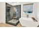 Bathroom with walk-in shower with black tiling, free standing tub and window at 401 Pirkle Ave, Buford, GA 30518