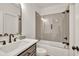 Modern bathroom features a tiled shower-over-tub with glass enclosure and dark vanity at 401 Pirkle Ave, Buford, GA 30518