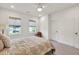 Bright bedroom features neutral tones, two windows with woven shades, and ceiling fan at 401 Pirkle Ave, Buford, GA 30518