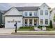 Elegant white brick home with a covered front porch, meticulous landscaping, and an attached garage at 401 Pirkle Ave, Buford, GA 30518