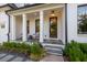 Inviting front porch with seating, beautiful landscaping, and a stylish front door at 401 Pirkle Ave, Buford, GA 30518
