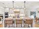 Bright kitchen with white cabinets, an island with seating, and modern pendant lighting at 401 Pirkle Ave, Buford, GA 30518