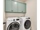 Modern laundry room features front load washer and dryer and shaker cabinets for storage at 401 Pirkle Ave, Buford, GA 30518