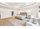 Bright main bedroom with a ceiling fan, large bed, a couch and an en-suite bathroom at 401 Pirkle Ave, Buford, GA 30518