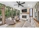 Relaxing screened porch with fireplace, comfortable seating, and a ceiling fan at 401 Pirkle Ave, Buford, GA 30518