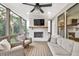 Inviting screened porch with a fireplace, tv, fan, and comfortable furniture at 401 Pirkle Ave, Buford, GA 30518