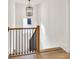 View of the top of the staircase with natural wood railing and wrought iron balusters at 401 Pirkle Ave, Buford, GA 30518