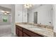 Bathroom vanity with granite countertop, double sinks, and dark wood cabinets at 2040 Bloomfield Ct, Cumming, GA 30041