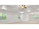 Spacious primary bedroom featuring tray ceiling, recessed lights, and large windows with views of the backyard at 2040 Bloomfield Ct, Cumming, GA 30041