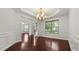 Formal dining room boasts wainscoting, hardwood floors, and a chandelier at 2040 Bloomfield Ct, Cumming, GA 30041