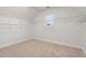 Spacious walk-in closet with carpeted floors, a window, and an abundance of wire shelving for optimal storage at 2040 Bloomfield Ct, Cumming, GA 30041