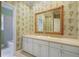 A bathroom with floral wallpaper, a white vanity, and a large mirror at 963 Bolingbrook Sw Dr, Marietta, GA 30064