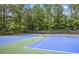 Outdoor tennis courts with green and blue surfaces and a backdrop of trees at 963 Bolingbrook Sw Dr, Marietta, GA 30064
