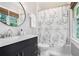 Bathroom features a vanity, commode, shower-tub combo with stylish shower curtain, and a bright window at 29 Greenland Trce, Atlanta, GA 30342