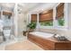 Bright bathroom features a soaking tub, glass-enclosed shower, and neutral tile at 29 Greenland Trce, Atlanta, GA 30342