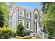 Beautiful gray painted brick home with white trim surrounded by mature trees and manicured landscaping at 29 Greenland Trce, Atlanta, GA 30342