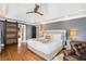 Comfortable main bedroom featuring a sliding barn door and a decorative ceiling fan at 29 Greenland Trce, Atlanta, GA 30342