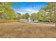 Charming single-story home with an ample yard, fence, and shed against a backdrop of lush, mature trees at 484 Lorene Sw Dr, Marietta, GA 30060