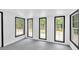 Bright room with gray floor, white walls, and multiple windows with black trim at 484 Lorene Sw Dr, Marietta, GA 30060