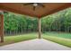 The covered outdoor patio has wood columns, a ceiling fan, and offers a beautiful green view of the backyard at 859 N Bay Overlook, Villa Rica, GA 30180