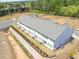 Aerial view of new townhomes with retention wall, landscaping and grassy lawns at 2407 Malster Ln, Lawrenceville, GA 30043