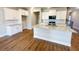 Open-concept kitchen with a large island, granite countertops, white cabinets, and stainless steel appliances at 2407 Malster Ln, Lawrenceville, GA 30043