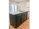 Kitchen island with granite countertop, stainless steel sink, and ample storage space with stylish hardware at 2407 Malster Ln, Lawrenceville, GA 30043